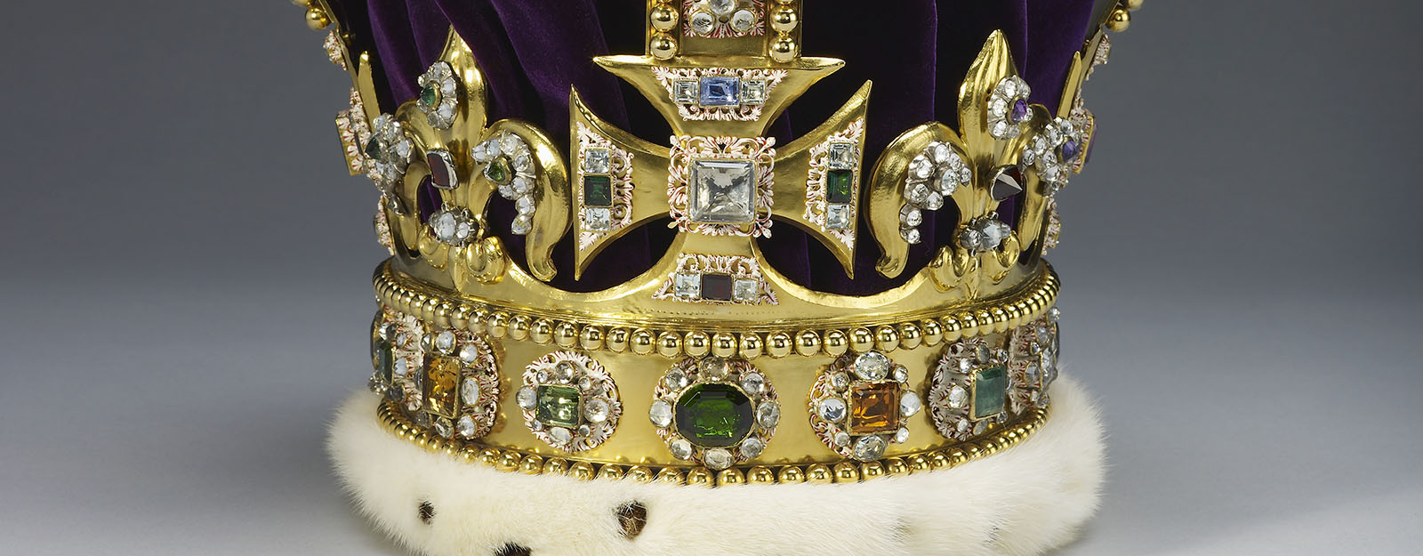 A close up of a gold crown set with jewels