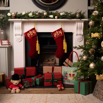 Red Velvet Christmas Stockings hang above a fireplace